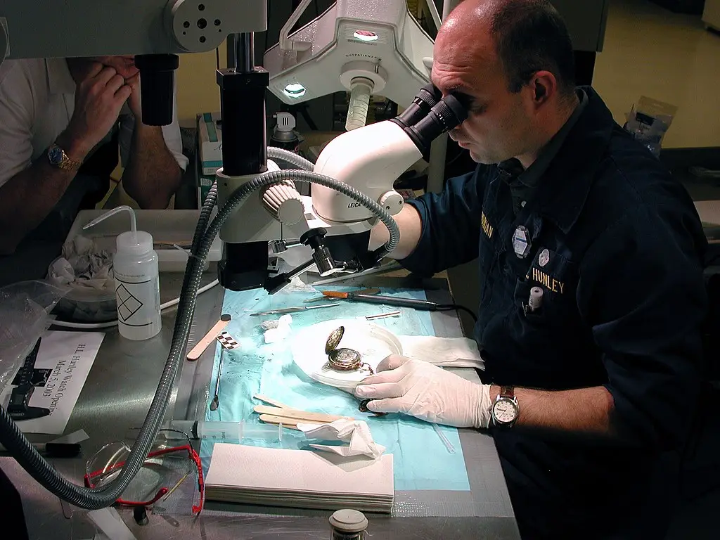 Paul Mardikian, uses a microscope to examine a pocket watch that belonged to the sub’s commanding officer, Lt. George Dixon