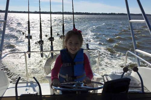 Young girl driving boat